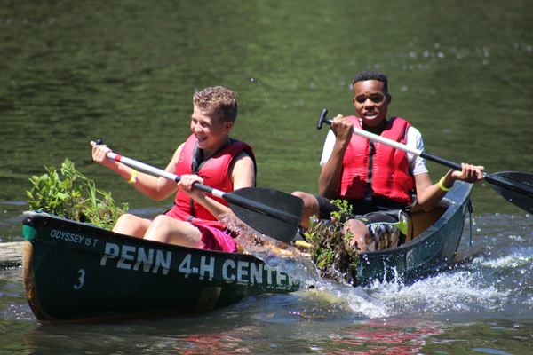 2 boys having a great time paddling a canoe.