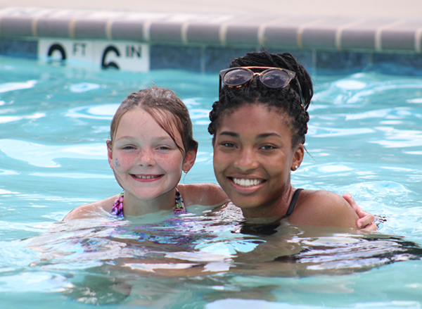 Camper and counselor smiling in the pool