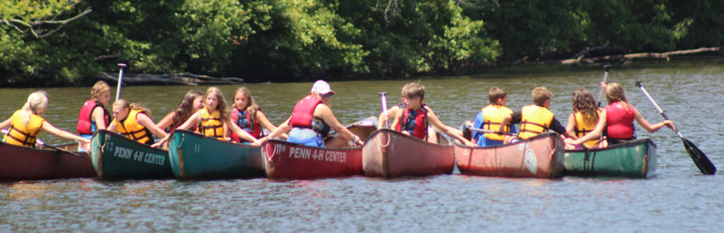 group holding their canoes together on the water
