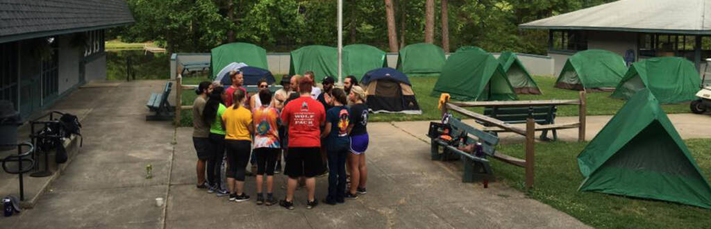 group talking after putting up tents for sleeping outside