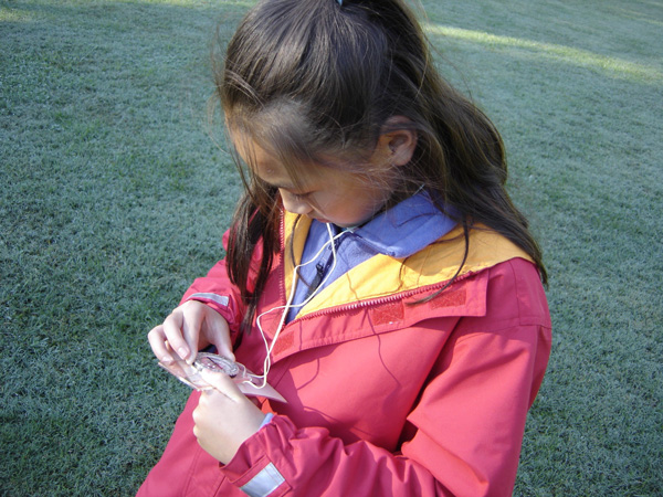 Girl looking at a compass for project orient lesson.