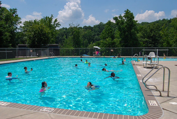 Group of campers in the swimming pool on a hot summer day.
