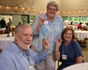 Group smiling and giving the Go Pack NC State sign