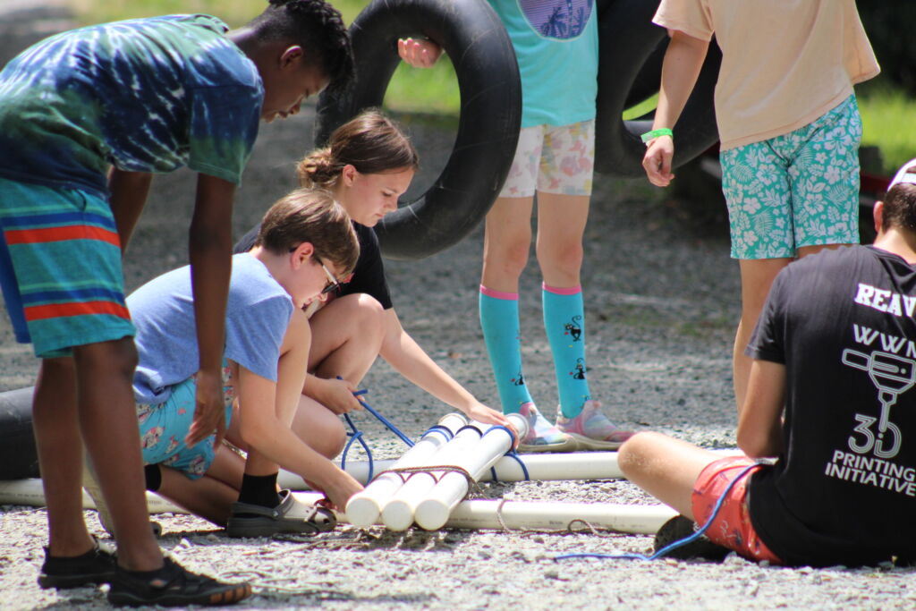 group working together to build something with pvc pipe
