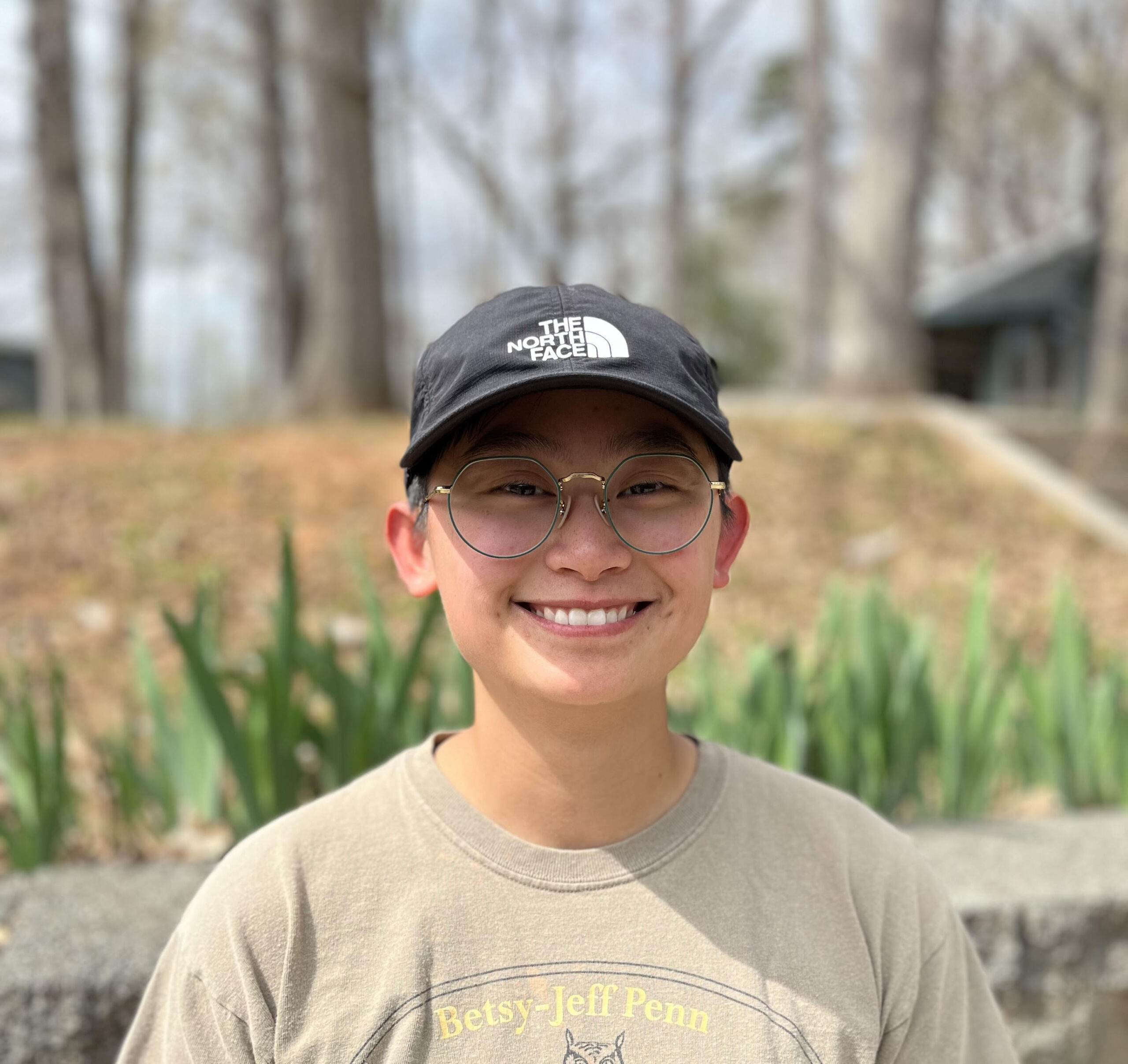 an outside photo of summer camp director zoe tate wearing a hat and smiling