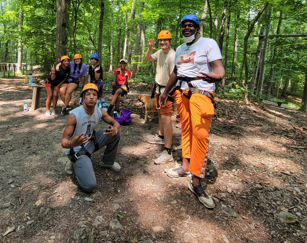 group of counselors at low ropes wearing rappelling gear