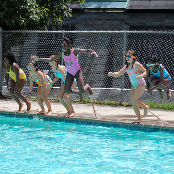 group of girls jumping into the swimming pool